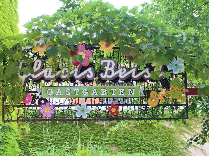 Bewachsenes Schild am Eingang zum Gastgarten des Glacis Beisl, einer der bekannten Gastgärten in Wien