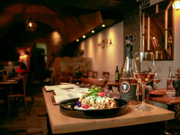 Gedeckter Tisch mit Gericht und Weinglas in einem Restaurant