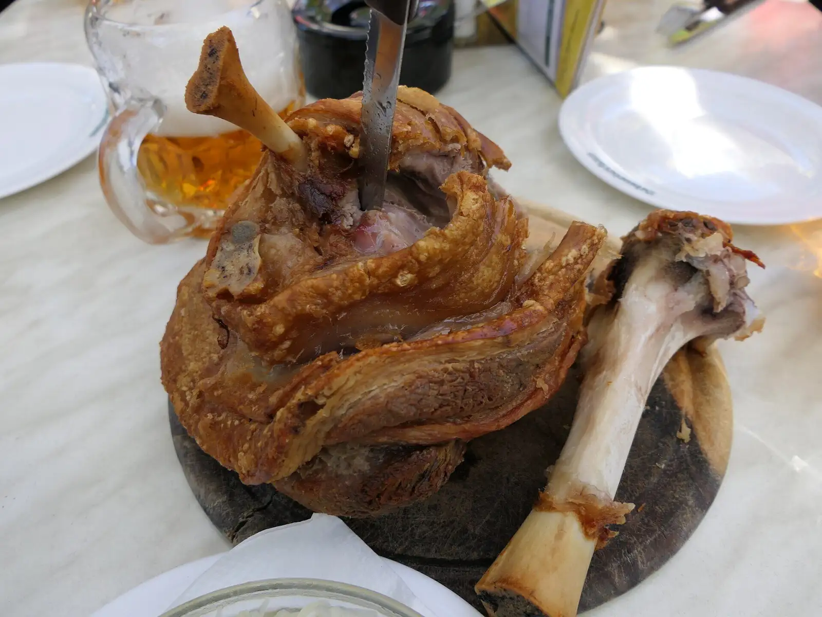 Schweinsstelze mit Bier auf einem Tisch im Schweizerhaus im Prater