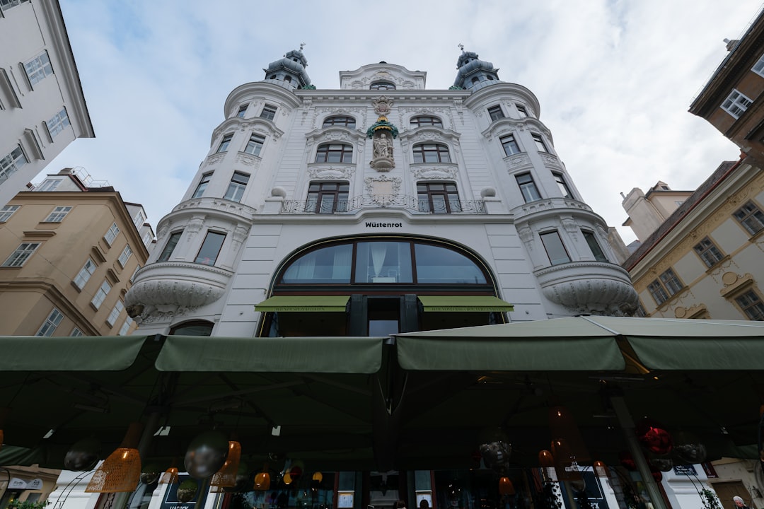 Ornate white building with green awnings in city