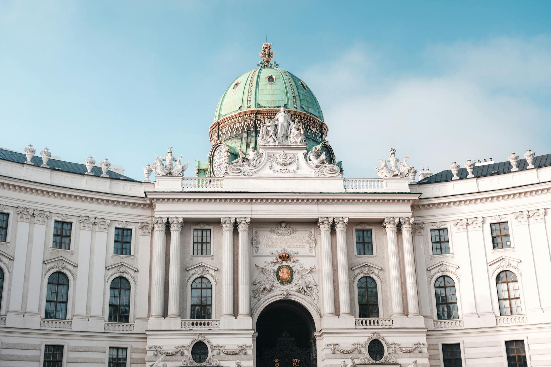 Elegant view of the Hofburg Palace's dome and facade in Vienna, Austria under a clear sky.