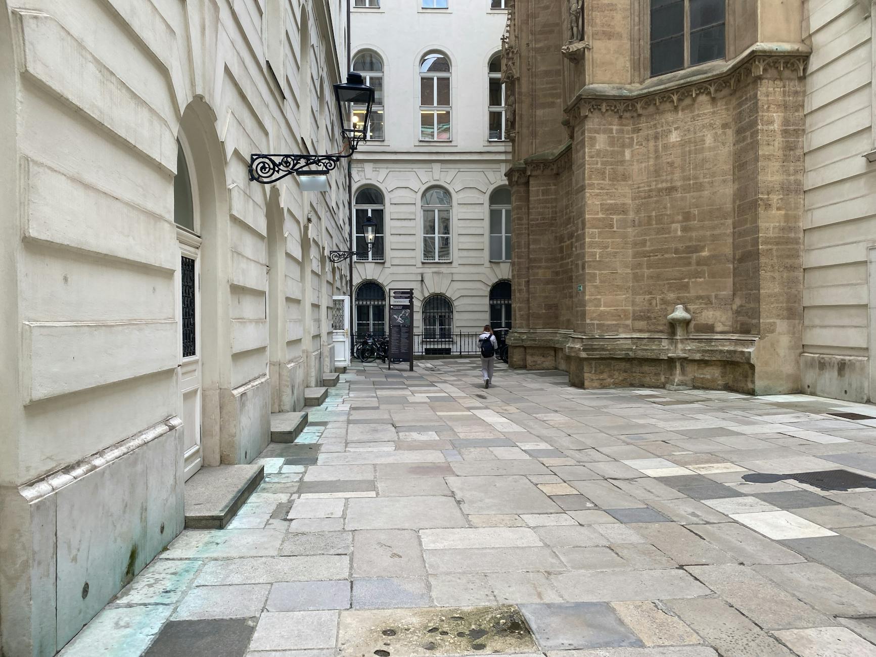Peaceful European alley with historic buildings, showcasing urban architecture and cobblestone pavement.