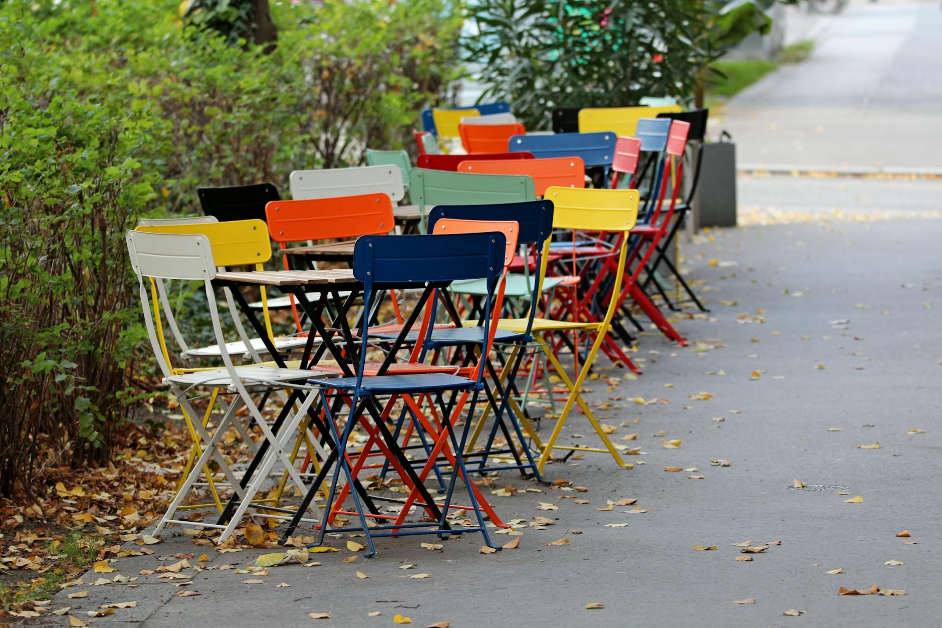 Vibrant chairs arranged along a sidewalk in autumn, Wien.
